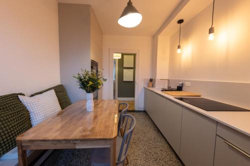 une cuisine avec une table en bois et des fleurs. dans l'établissement Urban chic - vacation & business, à Schiltigheim