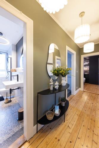 Cette chambre comprend un miroir et une table avec des fleurs. dans l'établissement Urban chic - vacation & business, à Schiltigheim