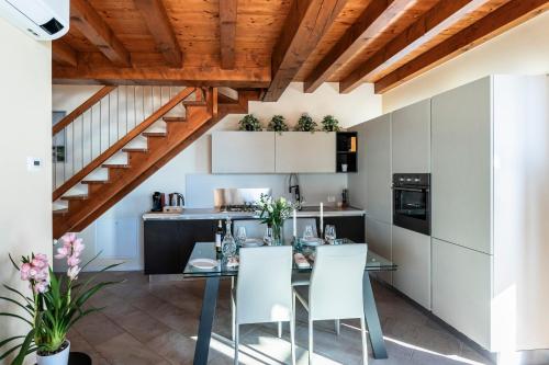 a kitchen with a glass table and white chairs at Iseo Lake Villa con vista lago e piscina in Costa Volpino