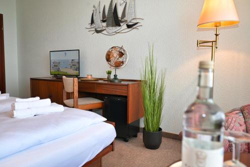 a hotel room with a desk and a bed at Strandhotel Salty in Büsum