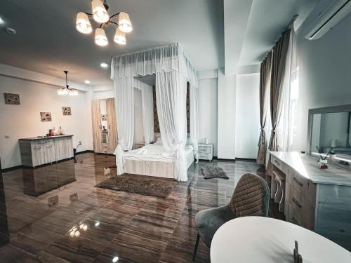 - un salon avec un lit blanc et une télévision dans l'établissement Splendor Boutique Pitesti, à Piteşti