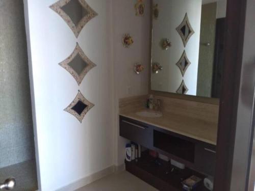 ein Badezimmer mit Waschbecken und Spiegel in der Unterkunft Casa Mccraren Torre 3-302 at Mayan Lakes in Playa Encanto