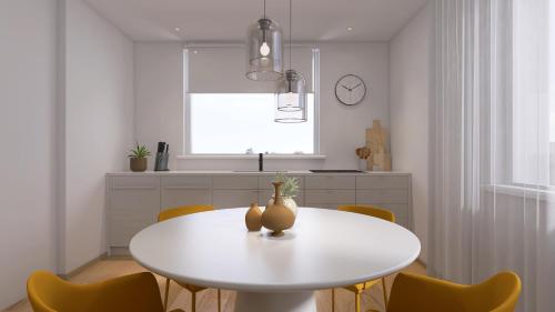 una sala da pranzo bianca con tavolo e sedie bianchi di Apartmenthaus am Kaiser-Wilhelm-Park a Detmold