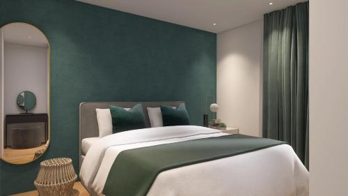 una camera da letto con un grande letto con una parete verde di Apartmenthaus am Kaiser-Wilhelm-Park a Detmold