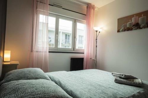 a bedroom with a bed and a window with pink curtains at *Cosy Home 20' Paris 25' Disney - Free WIFI* in Villiers-sur-Marne