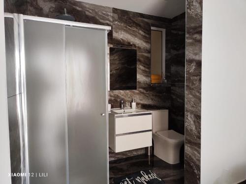 La salle de bains est pourvue d'un lavabo et de toilettes. dans l'établissement Luxury Sanap Heights apartment with communal pool, à Sannat
