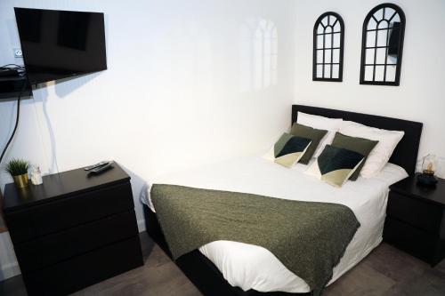 een slaapkamer met een bed en een flatscreen-tv bij Eiffel Tour Cosy Oliver in Parijs