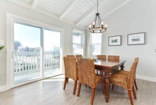 a dining room with a wooden table and chairs at Sunset Island 3 Level Home on the Water sleeps 10 in Sunset Beach