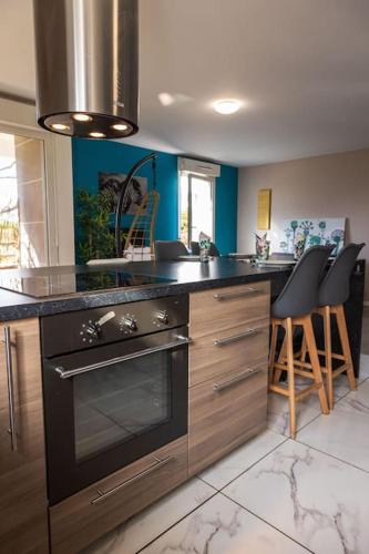 - une cuisine avec une cuisinière et un comptoir avec des tabourets dans l'établissement 2 BedRooms- 20' Paris - 25' Disneyland - WIFI, à Villiers-sur-Marne