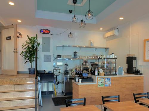 a restaurant with a counter and tables and chairs at Hometel Suites in Los Angeles