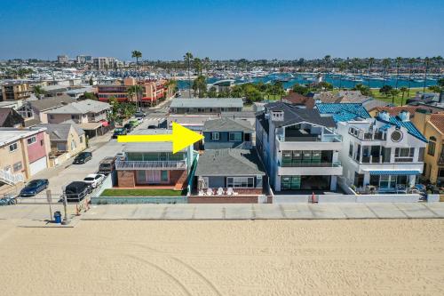 a yellow arrow on top of a house next to a beach at Oceanfront Back Home with View of the Sea in Newport Beach