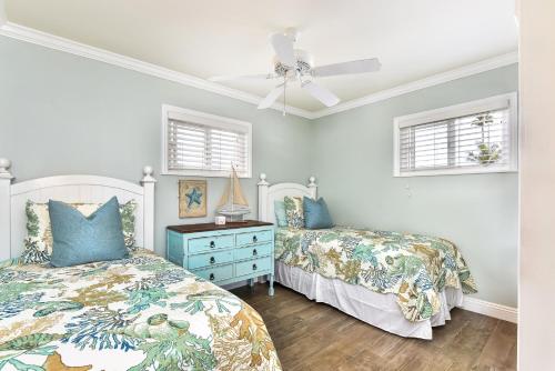 a bedroom with two beds and a ceiling fan at Oceanfront Back Home with View of the Sea in Newport Beach
