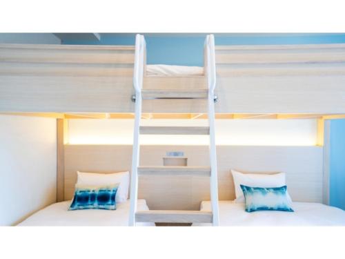 two bunk beds in a room with a ladder at Hotel Torifito Miyakojima Resort - Vacation STAY 79488v in Miyako Island