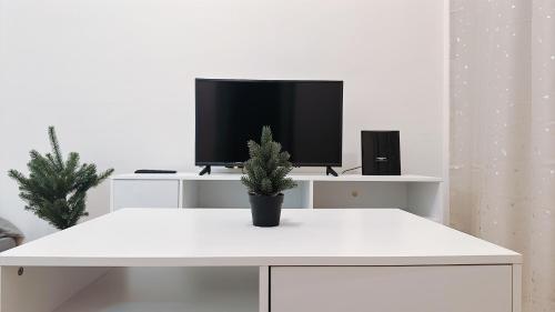 a white living room with a tv and a potted plant at Mount Austin Manhanttan Sovo by Cactus Homestay in Johor Bahru