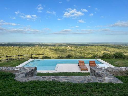 - une piscine avec 2 chaises dans l'établissement Casa en Ascochinga B.° cerrado. Sierras de Córdoba, à Córdoba