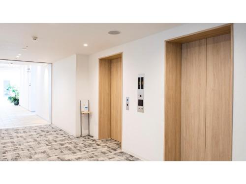 um corredor de escritório com portas de madeira e um corredor em Hotel Torifito Miyakojima Resort - Vacation STAY 79471v em Ilhas Miyako