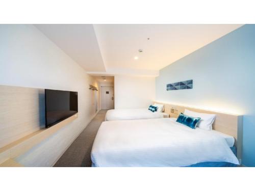 Habitación de hotel con 2 camas y TV de pantalla plana. en Hotel Torifito Miyakojima Resort - Vacation STAY 79481v, en Isla Miyako