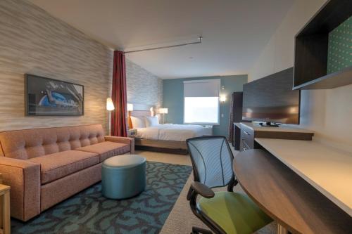 a hotel room with a bed and a couch at Home2 Suites By Hilton Allentown Bethlehem Airport in Bethlehem