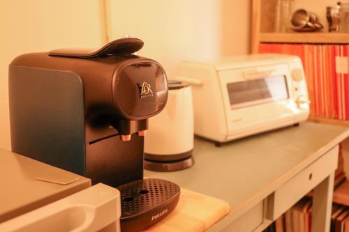 een koffiezetapparaat naast een magnetron bij B&B Zee-en-Zo in Noordwijk