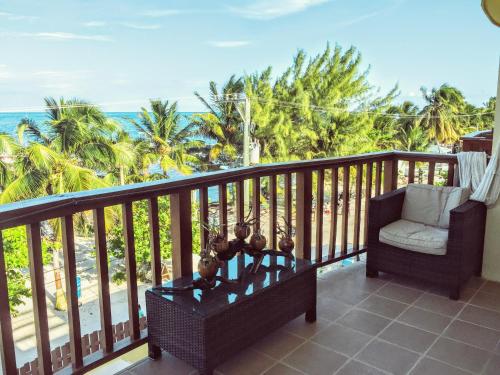 a balcony with a chair and a view of the ocean at Caye Reef Condos in Caye Caulker