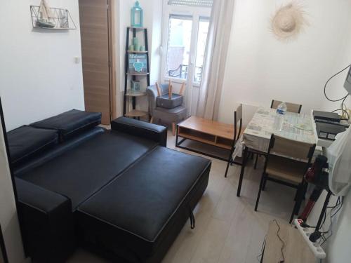 un salon avec un canapé noir et une table dans l'établissement location appartement Berck 350 m de la plage, à Berck-sur-Mer