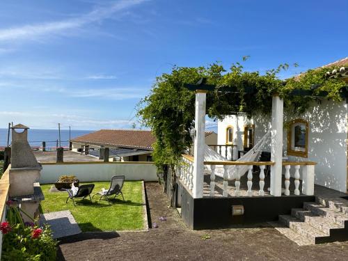 a house with a porch with a view of the ocean at Casa do Alemao in Porto Judeu