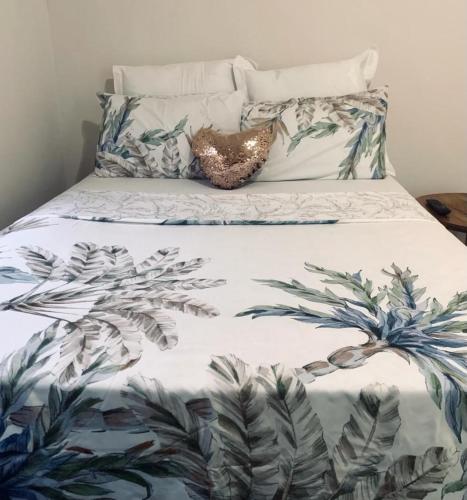 uma cama com um edredão azul e branco com plantas em Spacious Private room em Windhoek