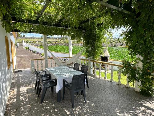 a patio with a hammock and a table and chairs at Casa do Alemao in Porto Judeu