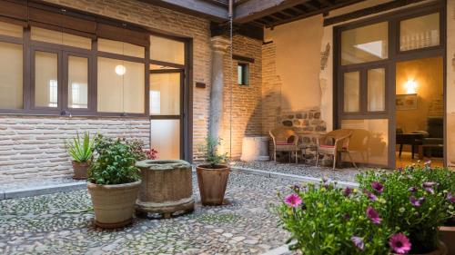 a courtyard with potted plants in front of a building at Casa de los Mozárabes by Toledo AP in Toledo