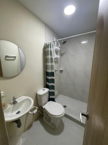 y baño con aseo, lavabo y ducha. en Villa Carolina SM en Santa Marta