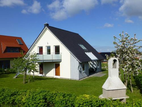 a small white house with a black roof at Holiday apartment sandpiper ground floor in Wohlenberg
