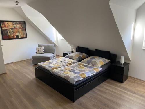 sypialnia z łóżkiem i krzesłem na poddaszu w obiekcie Holiday apartment w mieście Bernkastel-Kues