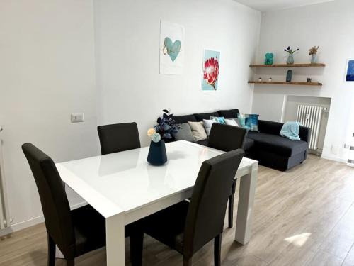 een witte eettafel met stoelen en een bank bij [Monza Centro in 10 Min]Comfort Suite XL in Monza