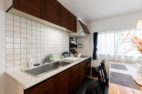 a small kitchen with a sink and a table at Capricious Inn - Vacation STAY 16154 in Ebetsu