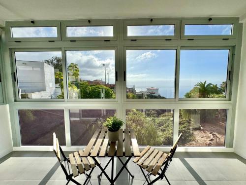 a table and chairs in a room with a large window at Mar & Teide in Sauzal