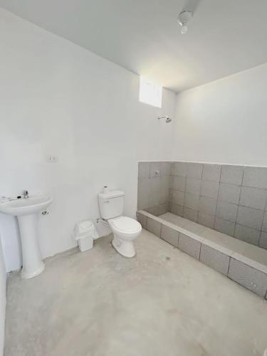 uma casa de banho branca com um WC e um lavatório em fundo los merino em Milla 7
