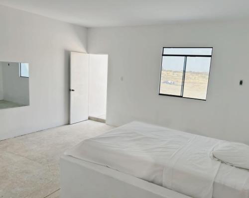 um quarto branco com uma cama e uma janela em fundo los merino em Milla 7