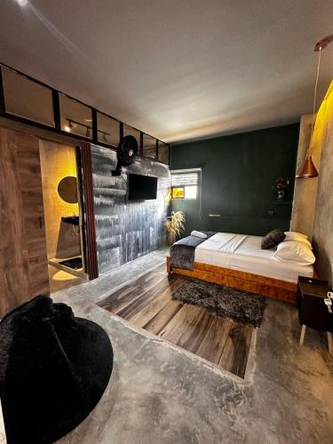 a bedroom with a bed and a green wall at Urban Hostal San Gil- Piscina Restaurante Bar in San Gil