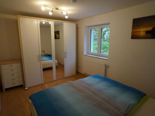 een slaapkamer met een bed en een grote spiegel bij Holiday apartment Flurgarten in Langenargen