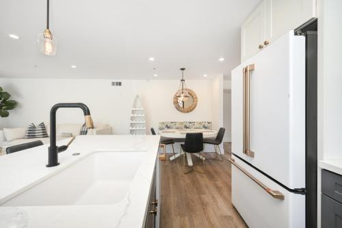 a kitchen with white countertops and a dining room at 3 Bedroom Renovated Condo on Balboa Island in Newport Beach