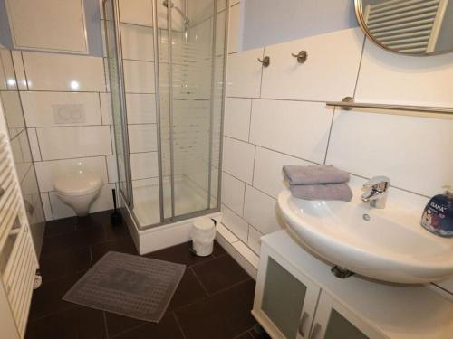 y baño con lavabo y ducha acristalada. en House beach holidays "above", en Wangerland