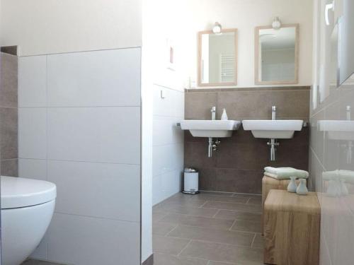 Un baño con dos lavabos y un inodoro. en Penthaus an der Harle, en Carolinensiel
