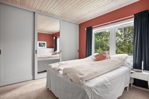 een slaapkamer met oranje muren en een grote spiegel bij House with iconic view in Tromsø