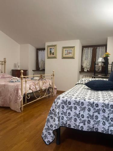 1 dormitorio con 2 camas y suelo de madera en La Torretta del Sementone, en Asís