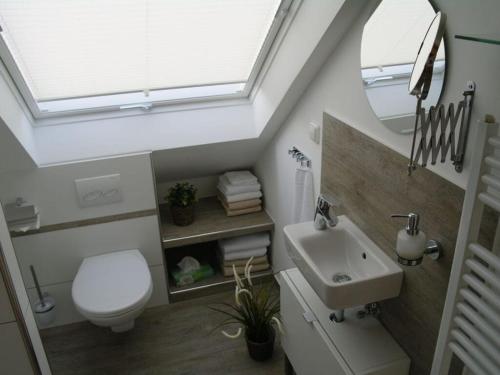 uma casa de banho com um WC branco e um lavatório. em Rauchkate Weibeck em Hessisch Oldendorf
