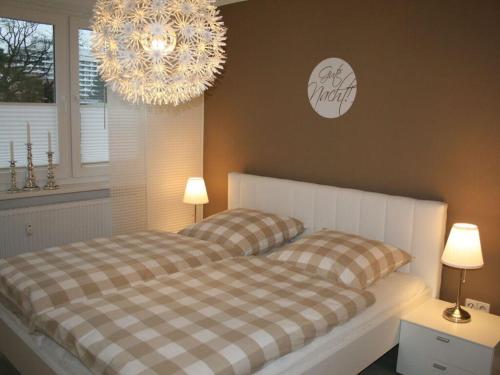 una camera con letto e lampadario a braccio di Holiday apartment Seega a Timmendorfer Strand