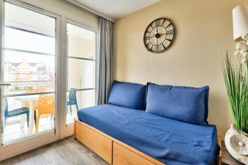 une chambre avec un lit et une horloge au mur dans l'établissement Résidence Port du Crouesty - maeva Home - Appartement 2 pièces 5 personnes - Confort MAE-1501, à Arzon