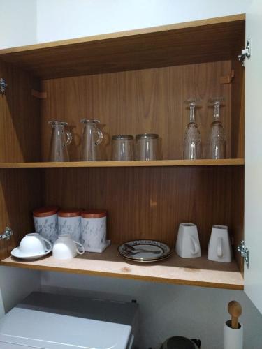 a wooden shelf with jars and dishes on it at Cheers in Evander