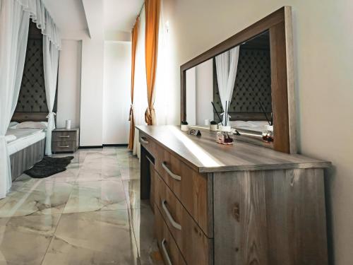 een badkamer met een houten wastafel en een grote spiegel bij Splendor Boutique Pitesti in Piteşti