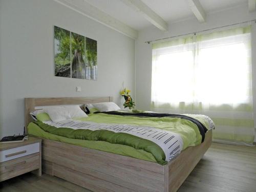 a large bed in a bedroom with a window at Holiday apartment deck boat in Hoddersdeich